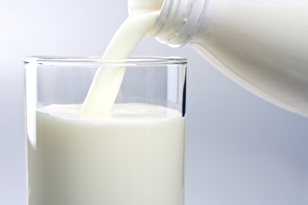 Молоко переливают из бутылки в стакан