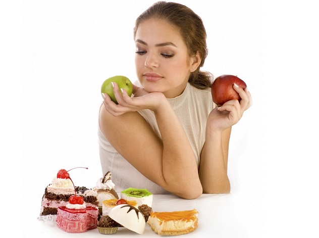 Девушка держит яблоки отказавшись от пирожных
