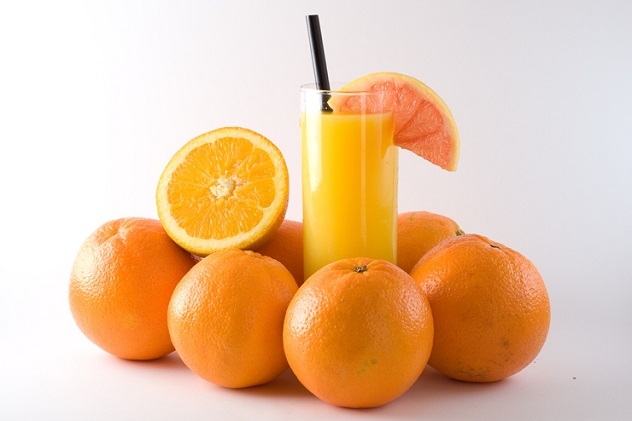 Целые апельсины и апельсиновый сок