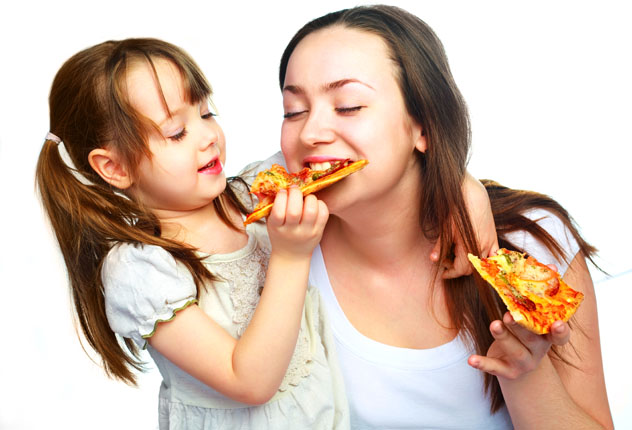 Мама с дочкой кушают пиццу