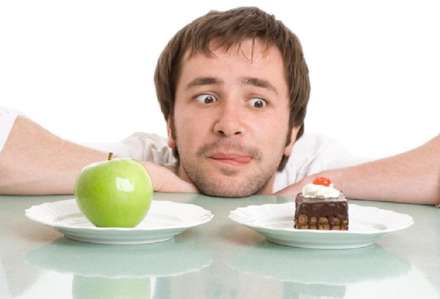 Мужчина смотрит на торт и яблоко