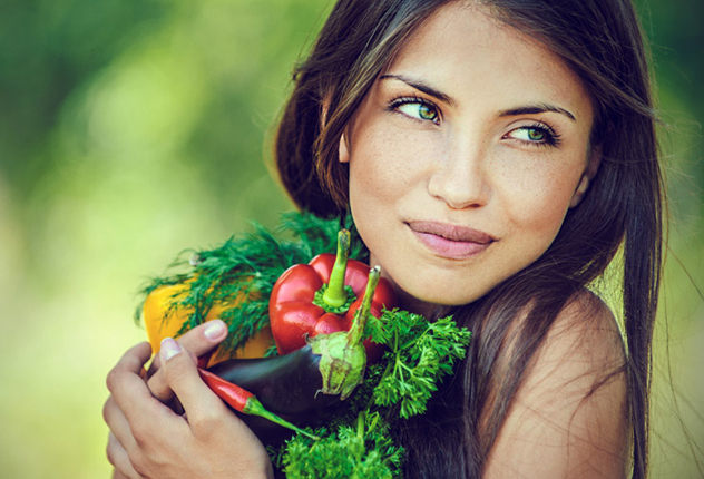 Девушка держит в  руках полезные овощи и зелень