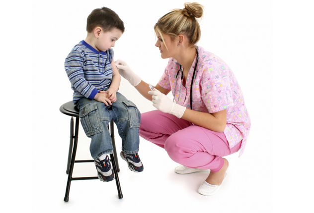Детский доктор ставит прививку маленькому мальчику