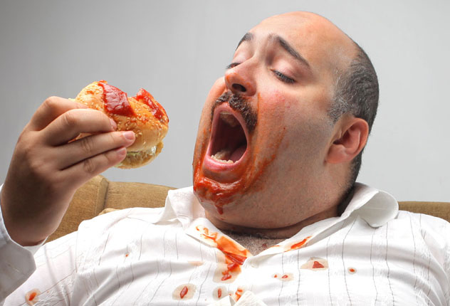 Толстый мужчина кушает вредную пищу