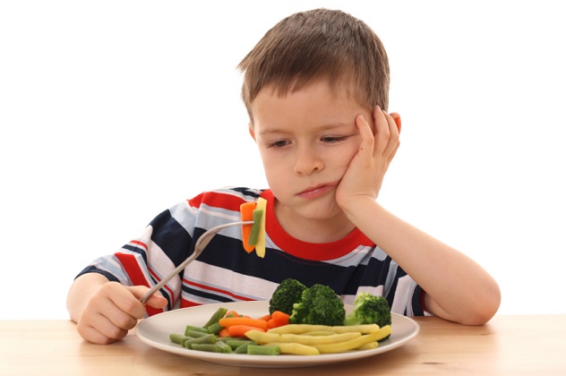 Мальчик сидит за столом и не хочет есть овощное рагу
