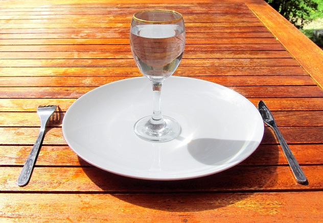Бокал воды в пустой тарелке