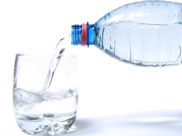 Минеральную воду из бутылки наливают в стакан