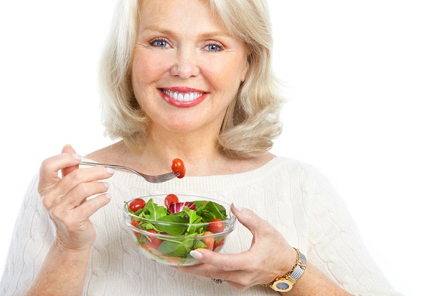 Счастливая женщина кушает салат