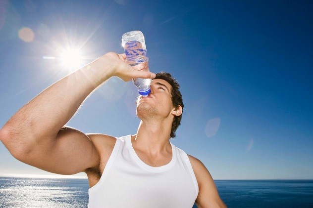 Мужчина пьет воду из бутылки