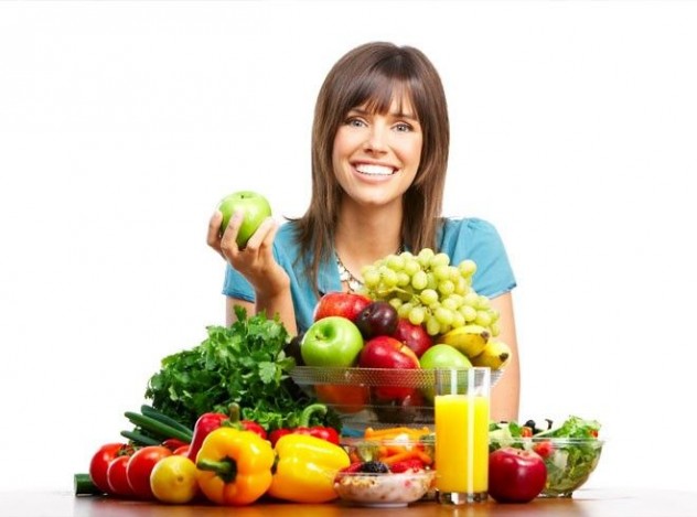 Женщина держит в руках фрукты и овощи